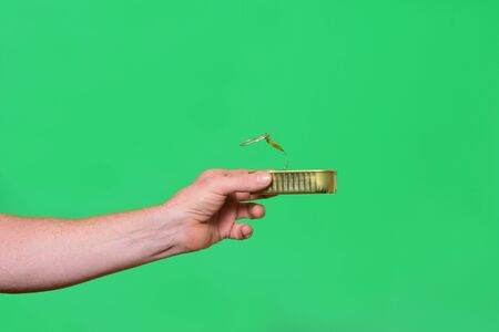 man holding a can on green backgroundの写真素材