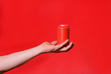 man holding a can on red backgroundの写真素材