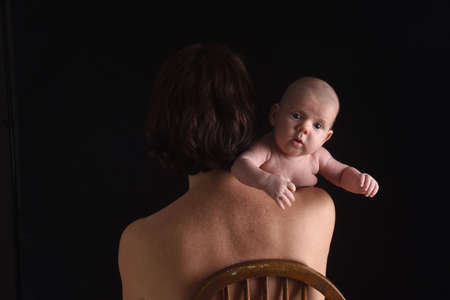 mother holding her son on black backgroundの写真素材
