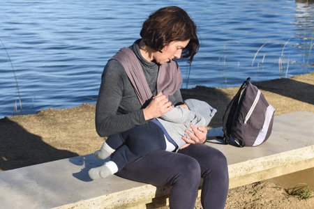 a close up of a mother dressed in sportswear breastfeeding her childの写真素材