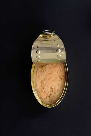 can of tuna on black background