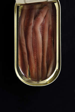 close up of top view of a can anchovy on black backgroundの写真素材