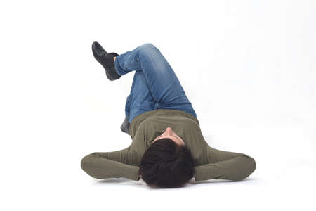 relaxed woman lying on the floor hand on head and legs crossed on white background