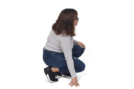 side view of woman squatting on white backgroundの写真素材