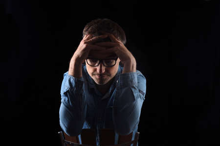 portrait of a man thimking on blackの写真素材