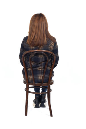back view of a woman sitting on chair on white backgroundの写真素材
