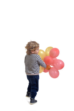 side back view of a baby playing with air balloon on white backgroundの写真素材