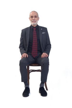 front view of a man sitting on chair with suit and looking at camera on white backgroundの写真素材