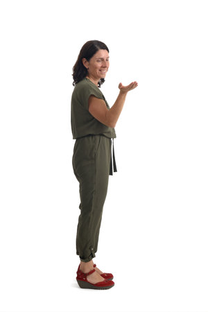side view of woman showing and looking at an imaginary object in her hand on white backgroundの写真素材