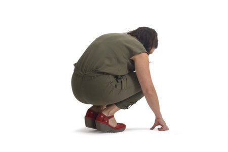 view of a woman squatting searching or looking at something on the floor on white background