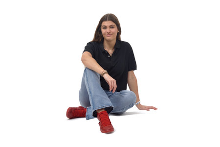 view of a young girl sitting on the floor looking at camera on white backgroundの写真素材