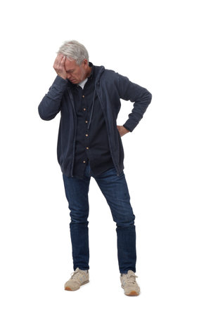 full length portrait of a man in headache pain isolated on whiteの写真素材