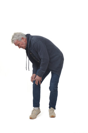 full length portrait of a man in knee pain in isolated on whiteの写真素材