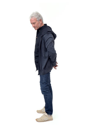 full length side view portrait of a man standing and looking down at the ground on white backgroundの写真素材