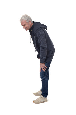 full portrait of side view of a man crouched down and looking at the floor and smiling on white backgroundの写真素材