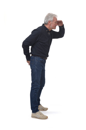 side view of standing man looking with hand on forehead on white backgroundの写真素材