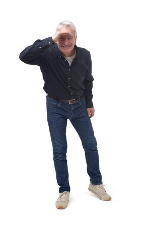 front view of standing man looking at camera with hand on forehead on white backgroundの写真素材