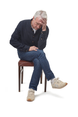 sad man sitting on chair on white backgroundの写真素材