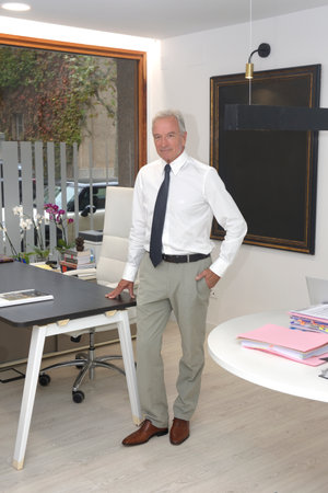 a businessman in his office standing and looking at cameraの写真素材
