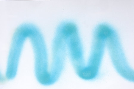 wavy line of blue, spray paint on white paper backgroundの写真素材