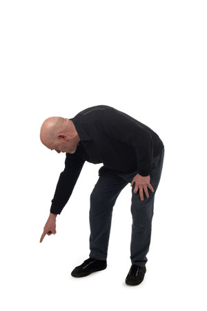 side view of a crouching man pointing finger at the ground on white backgroundの写真素材