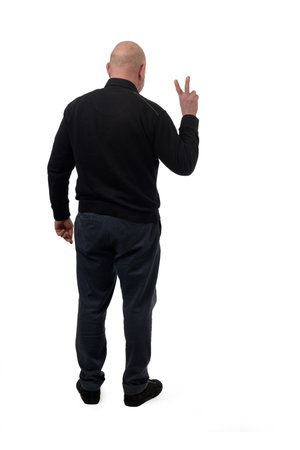back view of a man showing victory sign with fingers on white backgroundの写真素材