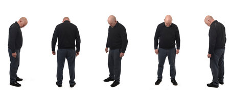group of same man standing looking at the floor searching for something on white background.の写真素材