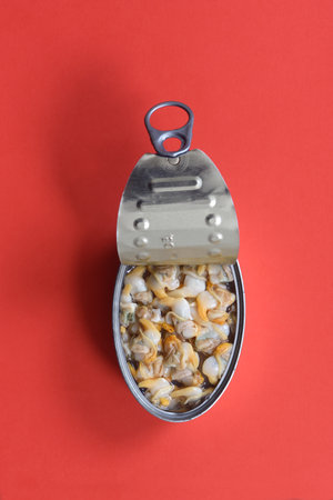 can of cockles on red background