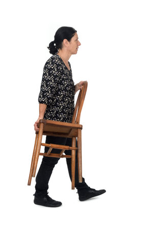 side view of a walking woman carrying chair on white backgroundの写真素材
