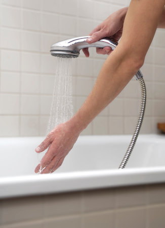 a hand checking the temperature of the bath water