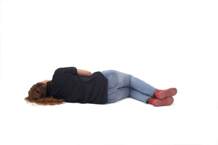 back view of a young girl lying on the floor on white backgroundの写真素材