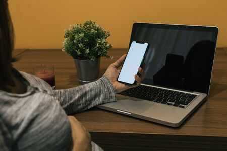 Pregnant white woman working with a laptop and phone on a wood table