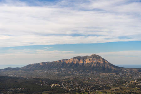 Mountain between villages on a clear day with few clouds, the sea in the background. In Alicante, Spain. Montgo Massif Natural Parkの写真素材