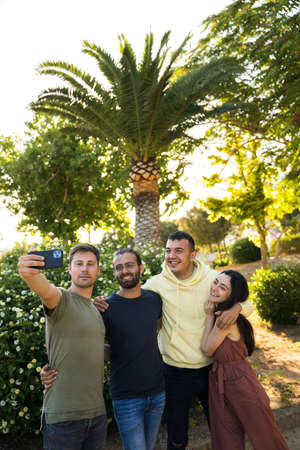 Happy friends taking a selfie in the park