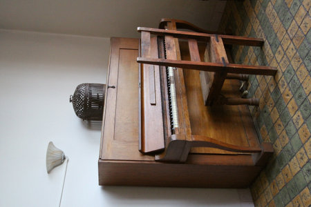 An antique organ with chair on an old tile floor.の写真素材
