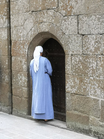 A religious sister opened the door of a French abbey in Normandy.の写真素材