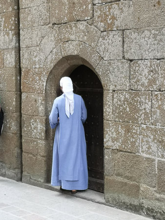 A religious sister opened the door of a French abbey in Normandy.の写真素材