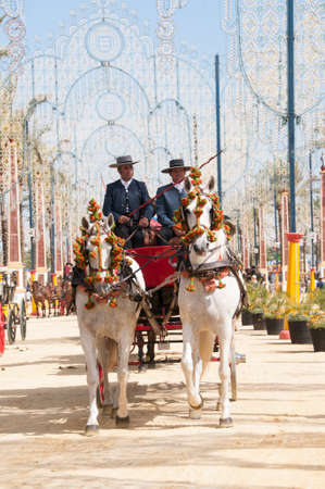 JEREZ DE LA FRONTERA, SPAIN-MAY 8: People on draft horses walking in the royal house of the fair at the Horse Fair on May 8, 2018 in Jerez de la Fronteraのeditorial素材