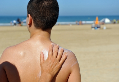 Skin protection at the beach with sunscreen, mother and childの写真素材