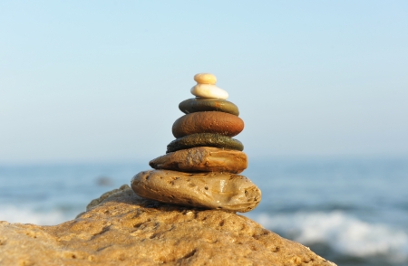 Stones balanced on a rock in the seaの写真素材
