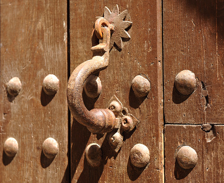 Wooden door with old iron knocker, monumental city of Caceres, Extremadura, Spain