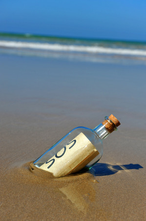Distress Message in a bottle found on the beach sandの写真素材