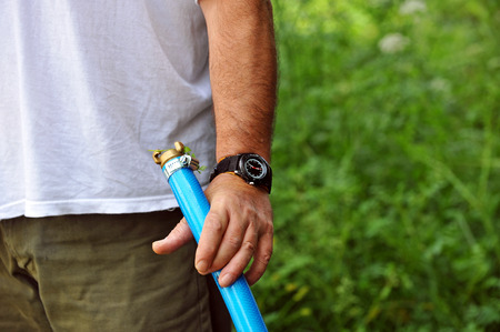 Man with hose for watering the gardenの写真素材