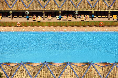Tourists sunbathing on the loungers at poolside, Carmona, Andalusia, Spainのeditorial素材