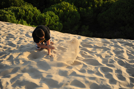 The dune of Bolonia, Natural park, boy climbing up, Tarifa, province of Cadiz, Andalusia, Spainの写真素材