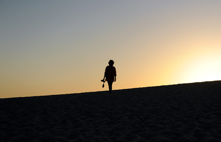 Young woman silhouette at sunset, dune in Bolonia, Natural park, Tarifa, province of Cadiz, Andalusia, Spainの写真素材