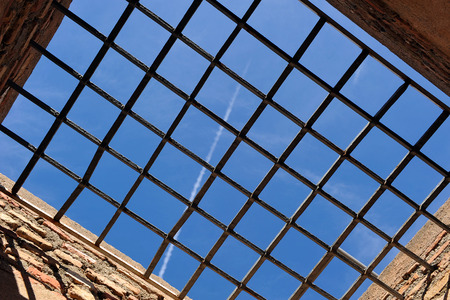 Blue sky through the grate, need for freedomの写真素材