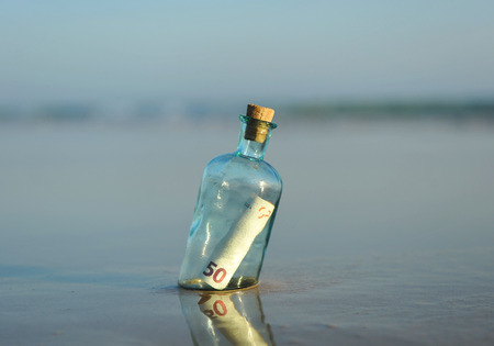 50 euro bills in a bottle found on the beachの写真素材