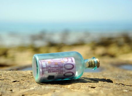Old glass bottle with 500 euro banknote insideの写真素材