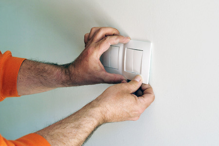 Electrician installing electrical switches in the new houseの写真素材